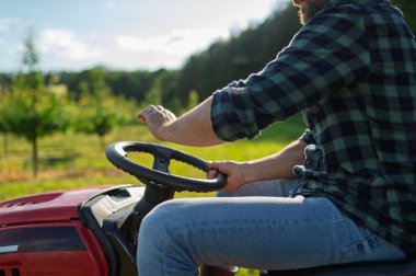 Çiftçinin meyve bahçesinde küçük bir traktör sürüşüne yakın, tek başına huzurlu bir anın tadını çıkarıyor..