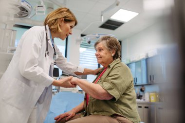 Nazik bir doktor yaşlı bir hastayı, nazik bir dokunuşla rahatlatıyor..