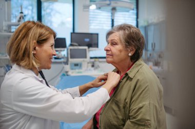 Geriatrist doktor steteskopla yaşlı hastayı muayene ediyor. Yaşlı kadınlar için rutin sağlık muayenesi.