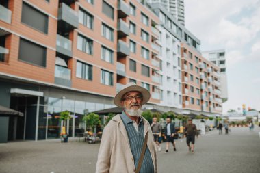 Kendine güvenen kıdemli adam sokağın ortasında duruyor, yeni şehri ziyaret ediyor..