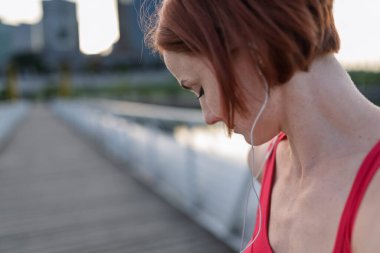 Sportif kadın koşucu sabah koşusuna hazırlanıyor, müzik dinliyor..