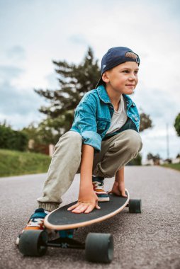 Şirin Çocuk sokakta uzun tahtasında oturuyor, tatilin tadını çıkarıyor..