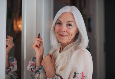 Üst düzey kadın aynanın önünde makyaj yapıyor, cilt rutini..