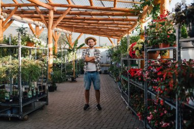 Bahçe merkezi sahibi saksıların arasında duruyor..