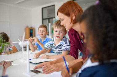 Küçük çocuklar sürdürülebilirliği, sınıfta öğretmenle rüzgar enerjisini öğreniyorlar.