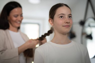 Anne banyoda kızlarını örüyor. Genç kızla sabah rutini.