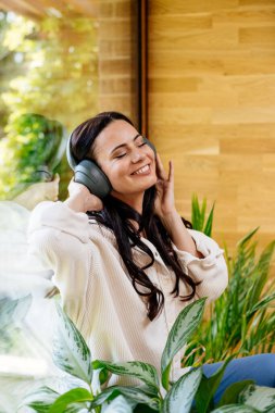 Rahat bir kadın boş zamanın tadını çıkarıyor, müzik dinliyor. Bencillik anı.