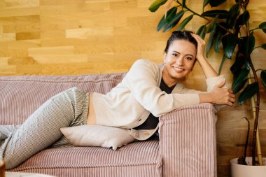 Rahat bir kadın kanepede dinleniyor. Evde huzurlu bir an..