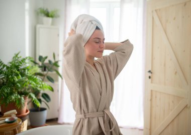 Genç bir kadın sıcak banyoda saç bakımından zevk alıyor. Kişisel bakım ritüeli.