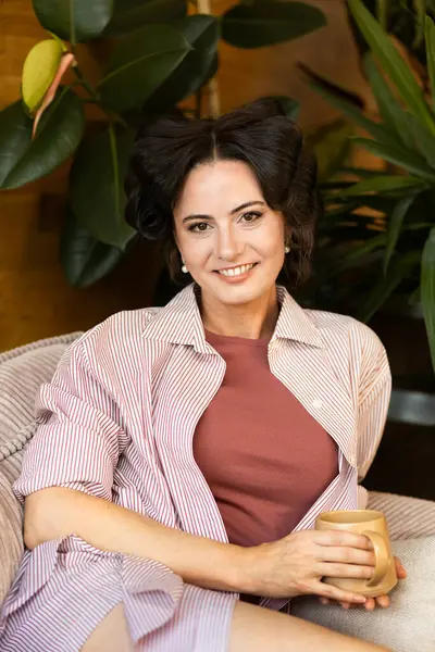 Yavaş sabahlarda saç bigudili kadın portresi. Kişisel bakım anı.