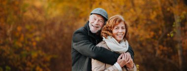 Yaşlı çiftler sonbahar sezonunda dışarıda vakit geçiriyorlar, fotokopi alanı ile pankart..