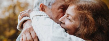 Yaşlı çifti kucaklamak, sonbahar sezonunda dışarıda vakit geçirmek, fotokopi alanı ile pankart..