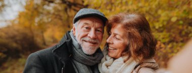 Yaşlı çiftler sonbahar sezonunda dışarıda vakit geçiriyorlar, fotokopi alanı ile pankart..