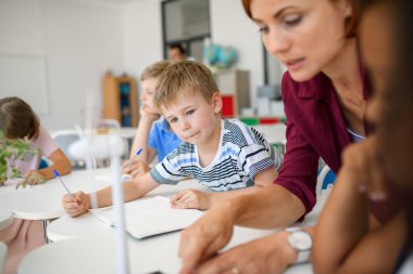 Küçük çocuklar sürdürülebilirliği, sınıfta öğretmenle rüzgar enerjisini öğreniyorlar.