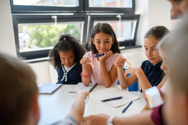 İlköğretim sınıfındaki çocuklarla etkileşimli bilim dersi, su saflığını test etmek.