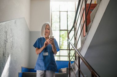 Hastane vardiyasında izin alıp ailesiyle mesajlaşmaktan yorgun düşmüş yaşlı hemşire..