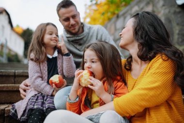 Kız kardeşler ve ebeveynler sıcak bir sonbahar günü parktalar. Hindistan yaz konsepti.