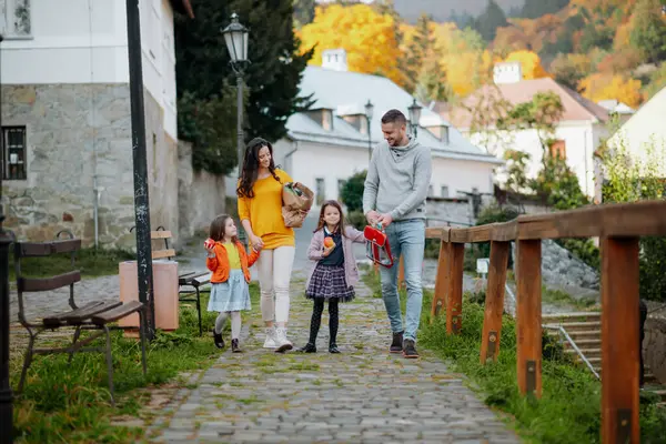 Kız kardeşler ve ebeveynler sıcak sonbahar gününde parkta yürürler. Hindistan yaz konsepti.