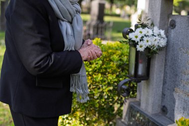 Mezarda dua eden yaşlı bir kadın. Azizler Günü.