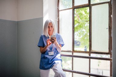 Yorgun hemşire ara veriyor, eski parçaların yanında durup ailesiyle mesajlaşıyor..