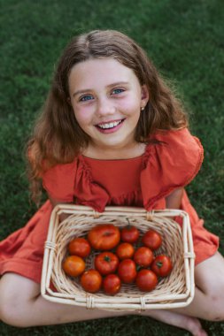 Sepeti olgun domateslerle dolu tatlı bir kız..