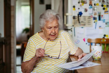 Üst düzey kadın sabah kahvesini ve günlük haberleri seviyor, gazete okuyor..