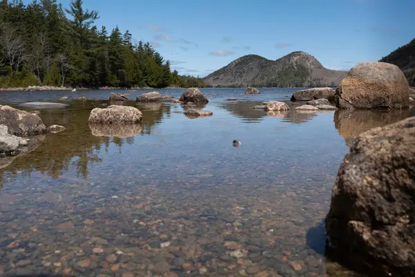 stock image Discover the serene beauty of Jordan Pond, nestled within the breathtaking landscapes of Acadia National Park in Maine. This freshwater lake, situated on Mount Desert Island, offers a tranquil escape surrounded by lush forests and majestic mountain. 