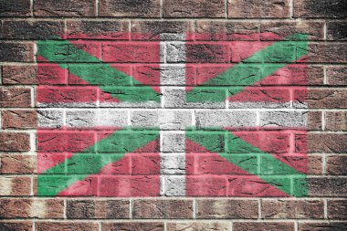 A Basque flag on a brick wall background