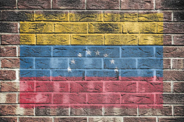 一面挂在砖墙背景上的委内瑞拉国旗 — 图库照片