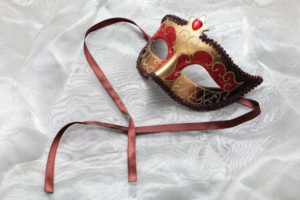 A Carnival Mask on white silk