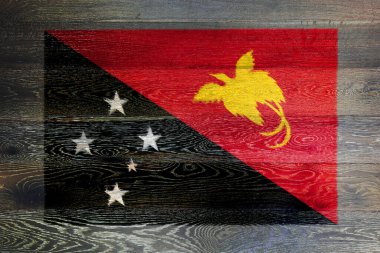 Kırsal eski ahşap arka planda Papua Yeni Gine bayrağı. Siyah kırmızı, güneyin kırmızı, paçavra kuşunun cennet kuşu.