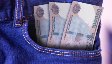 Kot pantolondaki 100.000 Özbekistan Som banknotunun bir kısmı harcama kavramını cebine atıyor