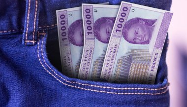 Bir kotun cebindeki 10000 CFA franklık banknotlar bir konsept harcama