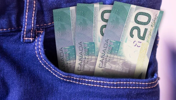 Bunch of Canada 20 Dollars banknotes in a jeans pocket a concept of spending