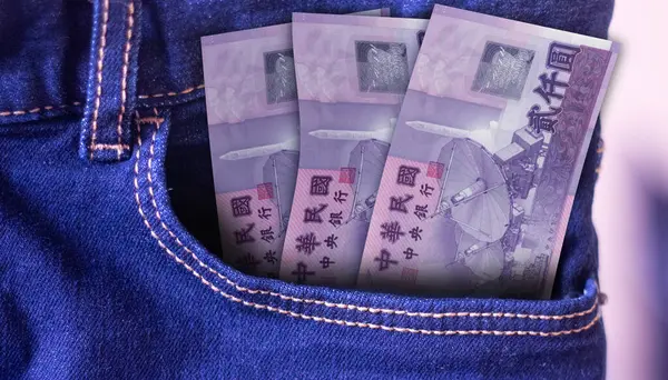 Bunch of New Taiwan dollar banknotes in a jeans pocket a concept of spending
