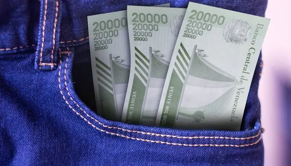 Bunch of Venezuela 20000 Mil Bolivares banknotes in a jeans pocket a concept of spending