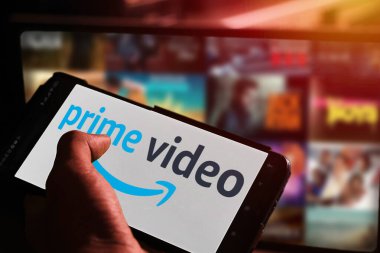 Pringsewu, Lampung; 20 Kasım 2023; Prime Video Streaming uygulaması olan akıllı telefonu ekranda tutan çocuk. Prime Video 'da yayınlanan filmlerin video arkaplanı ekranda bulanık. düzenleyici