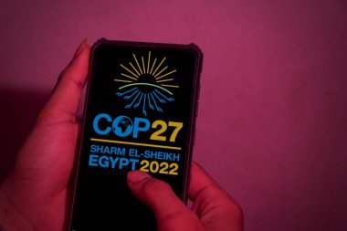 Pringsewu; Lampung; 16 Şubat 2023; Eller yukarı. Bu resim 2022 BM İklim Değişikliği Konferansı 'nın (COP27) logosunu cep telefonu ekranında gösteriyor. kırpma yolu