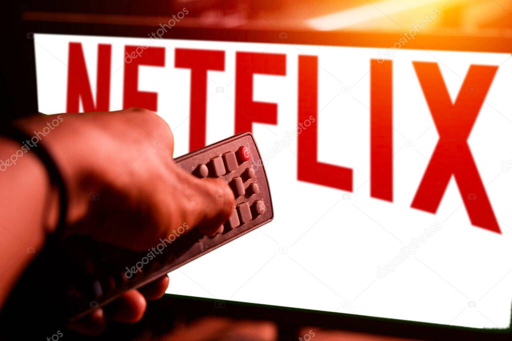 Pringsewu, Lampung; November 20, 2023; boy holding remote displays netflix logo on monitor. editorial video streaming company Netflix Inc