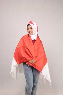 Kestane rengi elbiseli genç bir kadın elinde kırmızı ve beyaz bir bayrak, Endonezya 'nın bağımsızlık günü konsepti., 