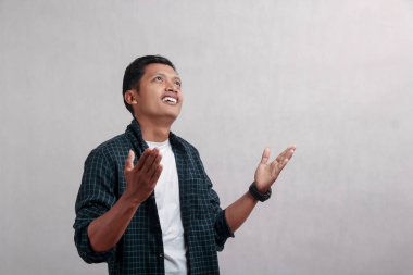 Elleri havada bir adam yukarı bakar ve gülümser..