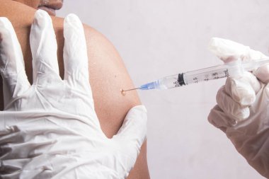 Yakın plan, yaşlı bir adama üst koldan bir doktor enjekte ediyor, seçici bir şırınga. sağlık kavramı