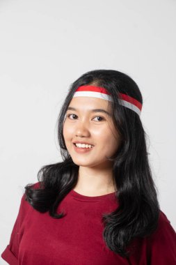 Yakından çekilmiş fotoğraf. Kestane renkli tişörtlü güzel bir kadın kameraya bakarken Endonezyalı kadın konsepti.