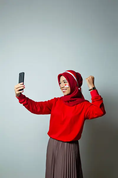 Endonezyalı Endonezyalı kadın Endonezya Bağımsızlığı Konsepti, mutluluk dolu mutlu bir ifadeyle cep telefonunda başarı hissi, kullanıcı kullanımı için reklam