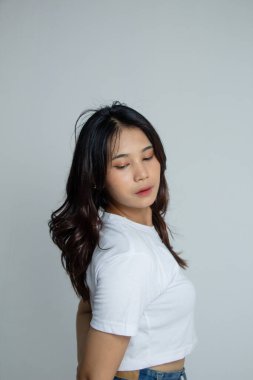 Beyaz gömlekli genç bir kadın şehvetli ve kendinden emin bir şekilde fotoğraf için poz veriyor..