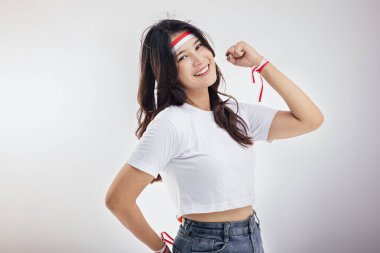 Endonezya 'nın bağımsızlık ruhuna sahip beyaz önlüklü Asyalı bir kadının doğal güzelliğine yakından bakınca kadın kırmızı ve beyaz bir saç bandı takıyor.