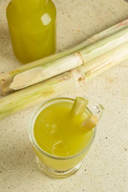 Top view of fresh sugar cane and sugar cane juice on marble white table