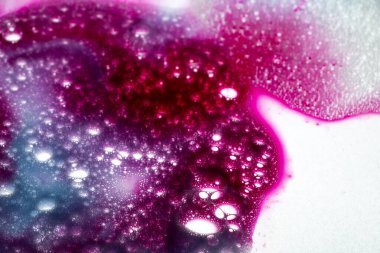 Beyaz ışıklı kumaş üzerinde kırmızı ve mavi mürekkeple sıvı baloncuk su sabunu dokusu, pürüzsüz fotoğraf