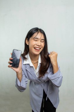 Kadınlar akıllı telefonlarda başarılı olurlar. Açık mor bir gömlek giyiyor, ayakta duruyor ve neşeli bir yüzle sarılıyor. Beyaz arka planda izole edilmiş ofis kadını