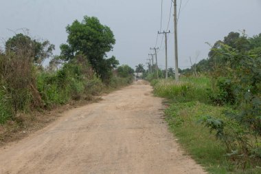 Endonezya, Lampung 'da bir köyün içinde hasarlı yollar, taştan yollar ve kuru toprak görüldü.